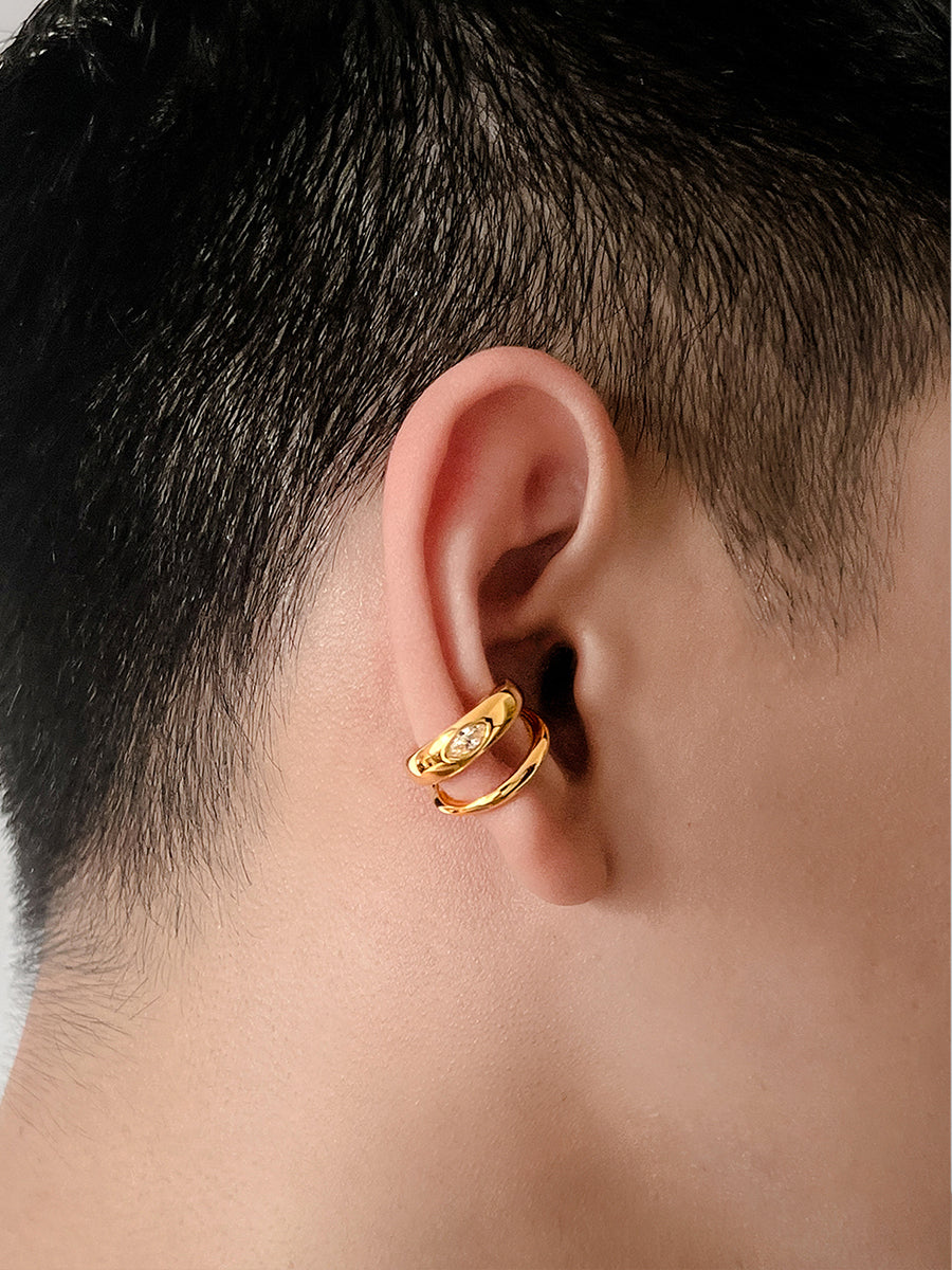 Arcenkelab Classic Ear Cuff in gold and silver finishes. This polished accessory offers versatile style, perfect for layering or solo wear.