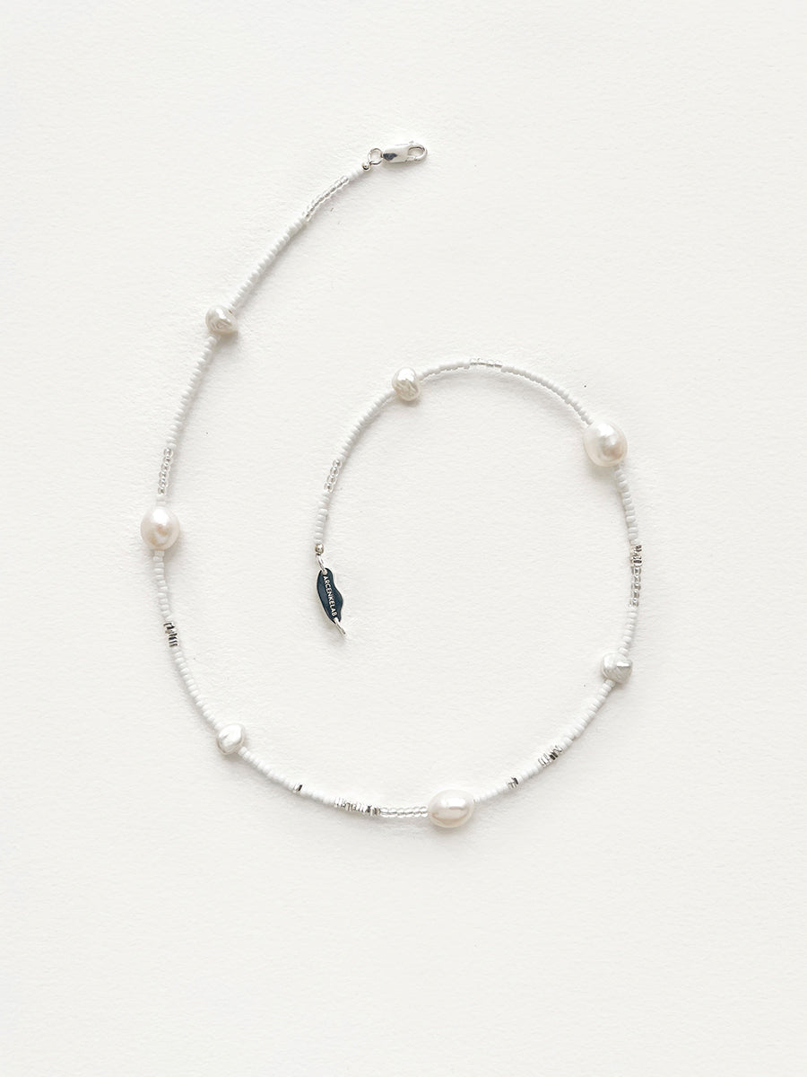 Arcenkelab's pearl necklace features natural pearls and 925 silver on a fine chain, offering understated elegance. Perfect for layering or solo wear, it adds a refined touch to everyday outfits.