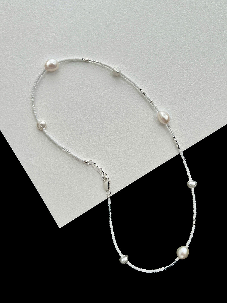 Arcenkelab's pearl necklace features natural pearls and 925 silver on a fine chain, offering understated elegance. Perfect for layering or solo wear, it adds a refined touch to everyday outfits.