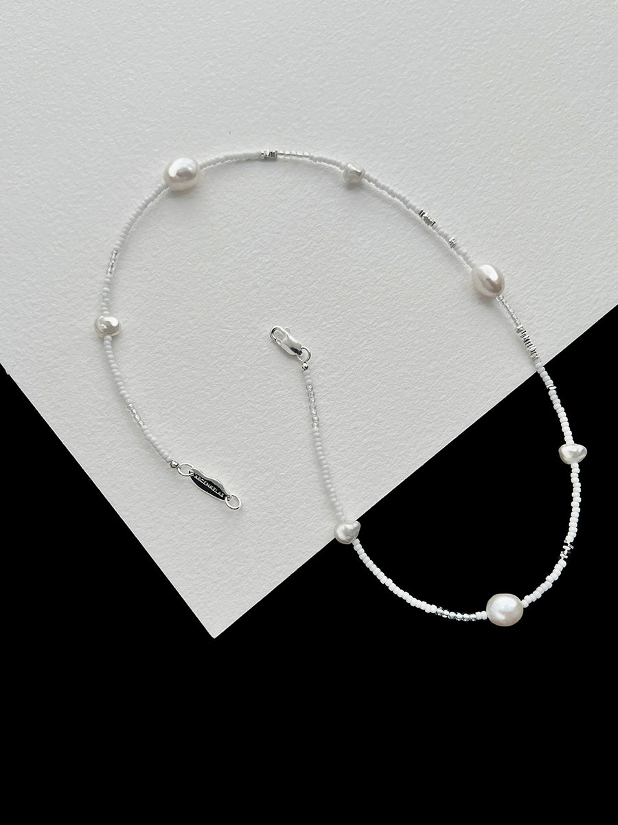 Arcenkelab's pearl necklace features natural pearls and 925 silver on a fine chain, offering understated elegance. Perfect for layering or solo wear, it adds a refined touch to everyday outfits.