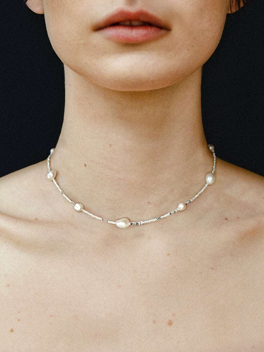 Arcenkelab's pearl necklace features natural pearls and 925 silver on a fine chain, offering understated elegance. Perfect for layering or solo wear, it adds a refined touch to everyday outfits.