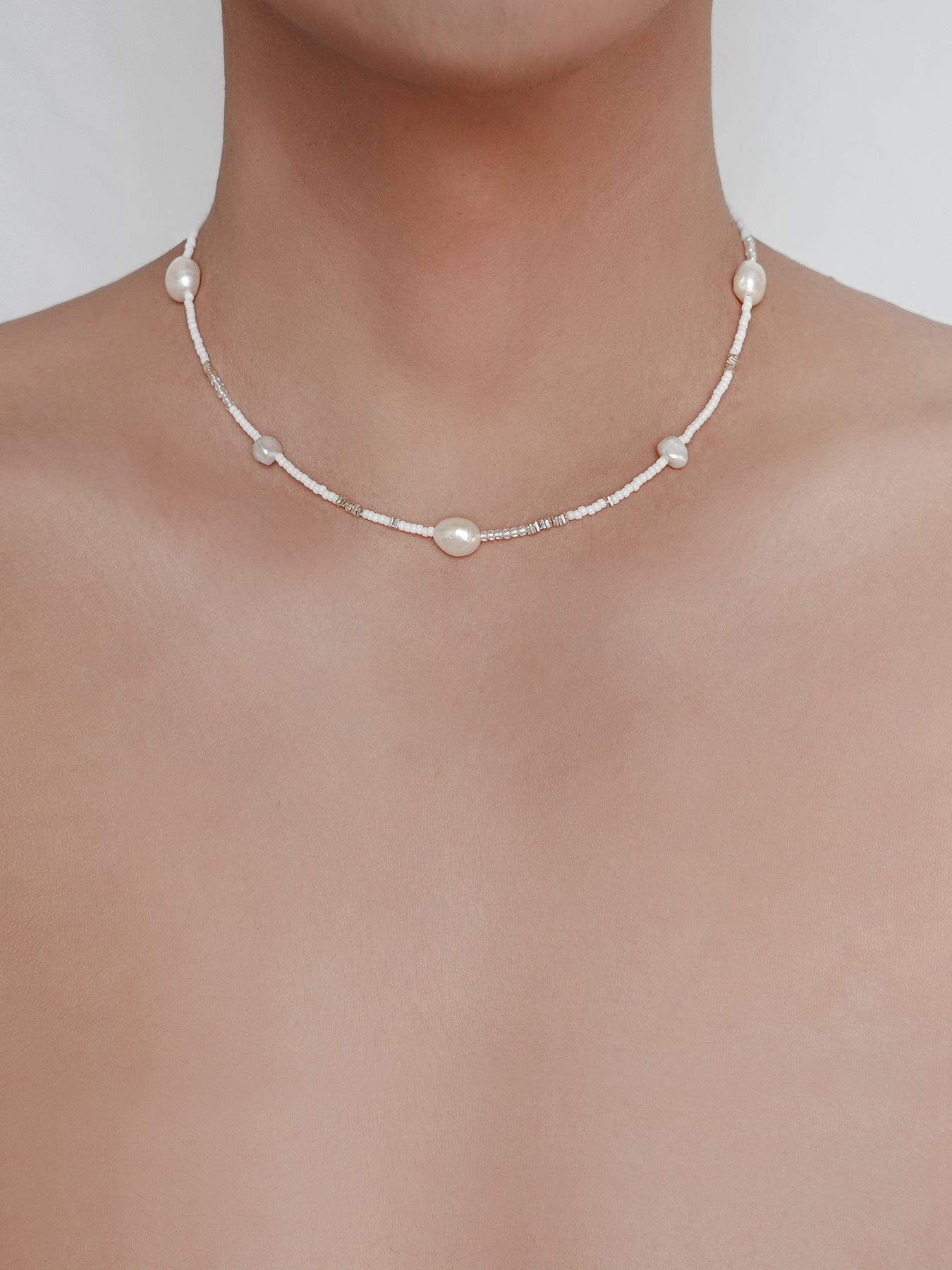 Arcenkelab's pearl necklace features natural pearls and 925 silver on a fine chain, offering understated elegance. Perfect for layering or solo wear, it adds a refined touch to everyday outfits.
