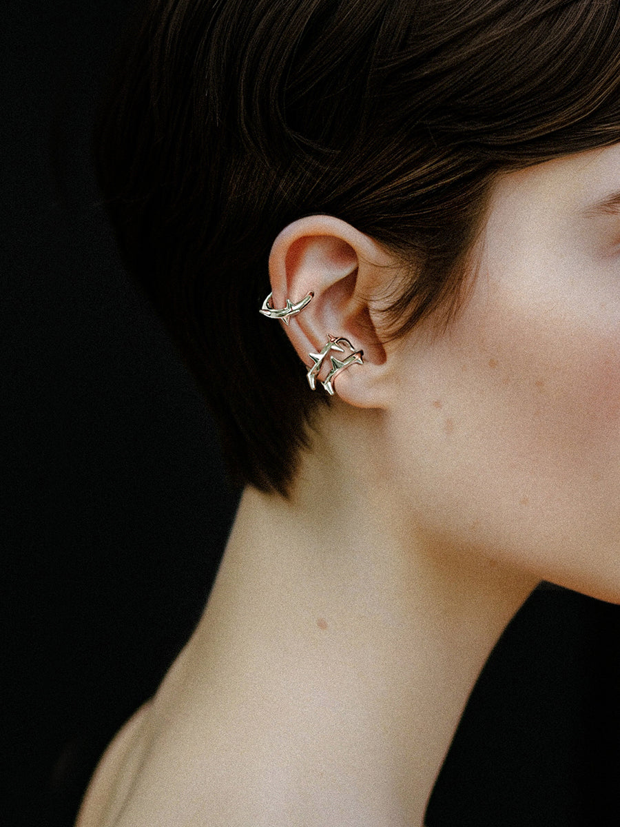Arcenkelab Rose Thorn Ear Clip in polished gold and silver, featuring thorn-inspired lines for a unisex, versatile accessory.