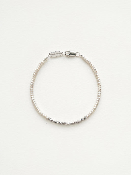 Discover the Arcenkelab Mini Pearl and Silver Necklace—a timeless blend of elegance and simplicity. Perfect for any occasion, this handcrafted piece features delicate pearls and sleek silver, making it versatile for all styles, genders, and ages.