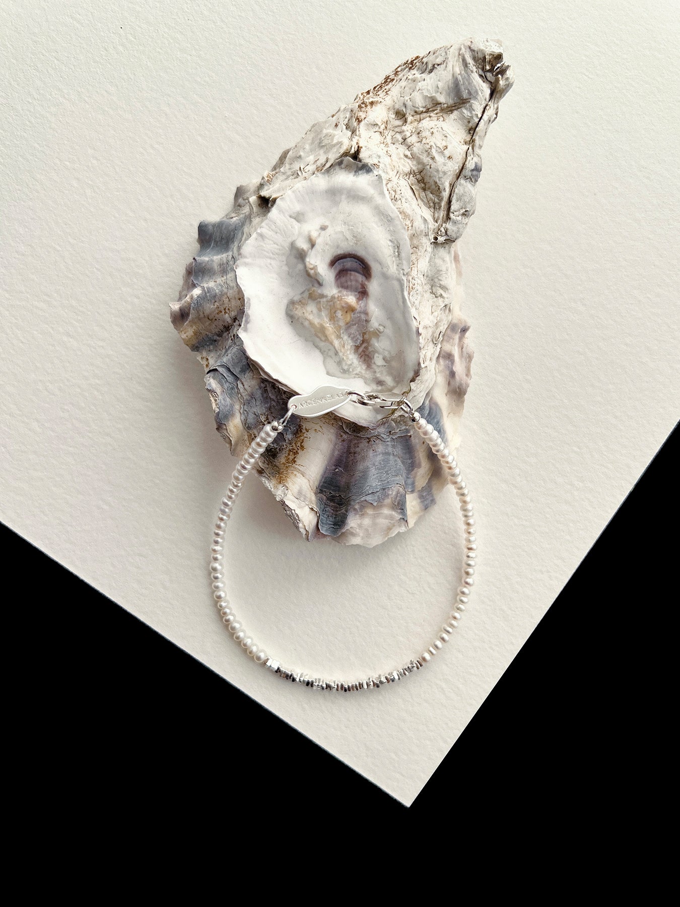 Discover the Arcenkelab Mini Pearl and Silver Necklace—a timeless blend of elegance and simplicity. Perfect for any occasion, this handcrafted piece features delicate pearls and sleek silver, making it versatile for all styles, genders, and ages.